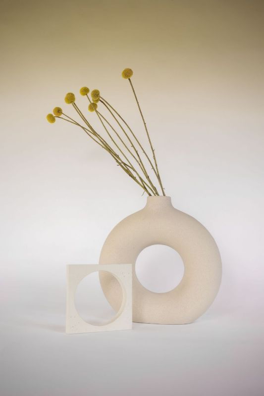 Vase en céramique en forme d’anneau avec des fleurs jaunes