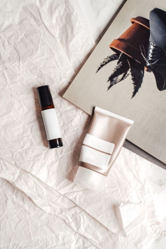Un tube et un flacon de cosmétique sans marque sur du papier froissé