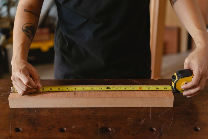 Mesure d’un liteau en bois avec un mètre ruban