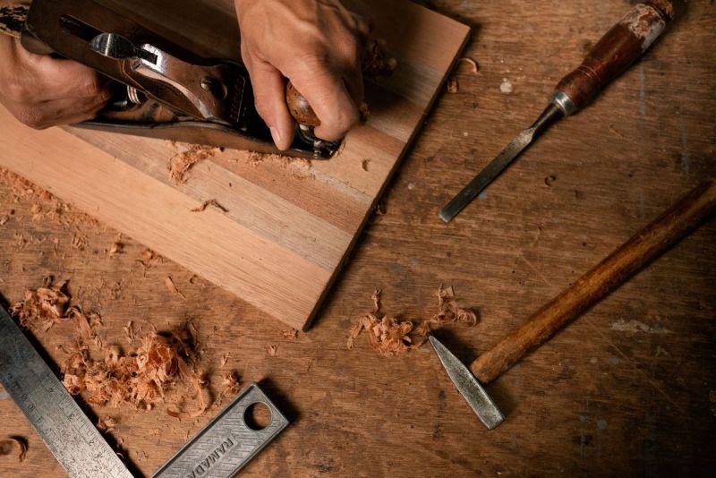 Rabot, ciseaux à bois et copeaux sur une planche