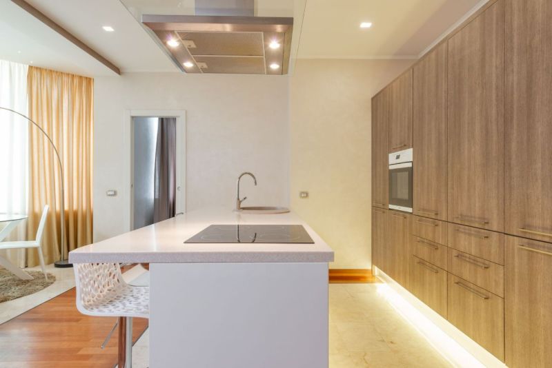 Cuisine minimaliste avec meubles en bois clair et plan de travail blanc