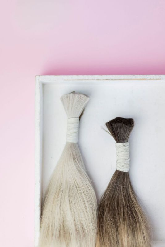 Due ciocche, una bionda e una castana, in un vassoio bianco