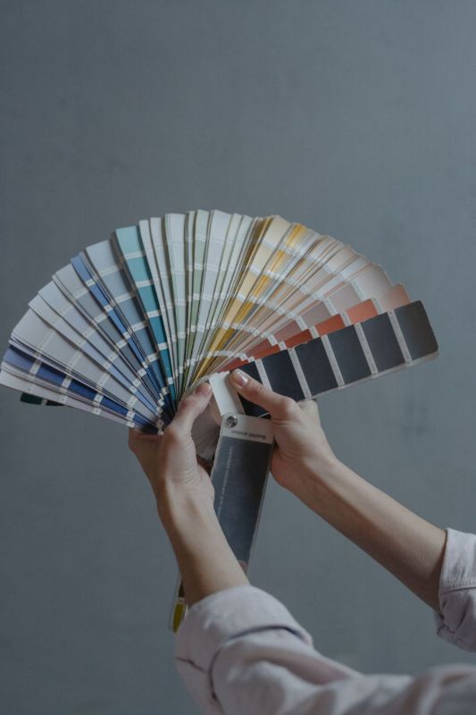 Mani che tengono un ventaglio di campioni di colore