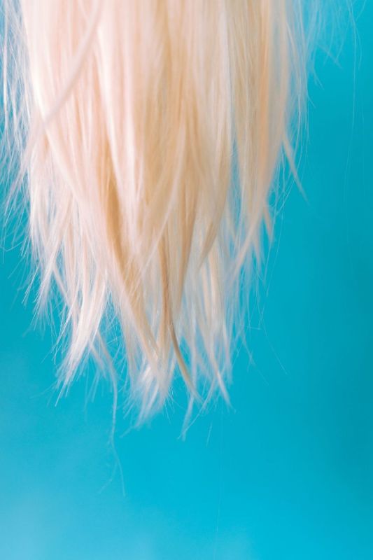 Lunghi capelli biondi sciolti su sfondo azzurro