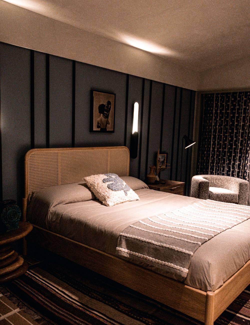 Chambre aux tons sombres avec tête de lit en rotin
