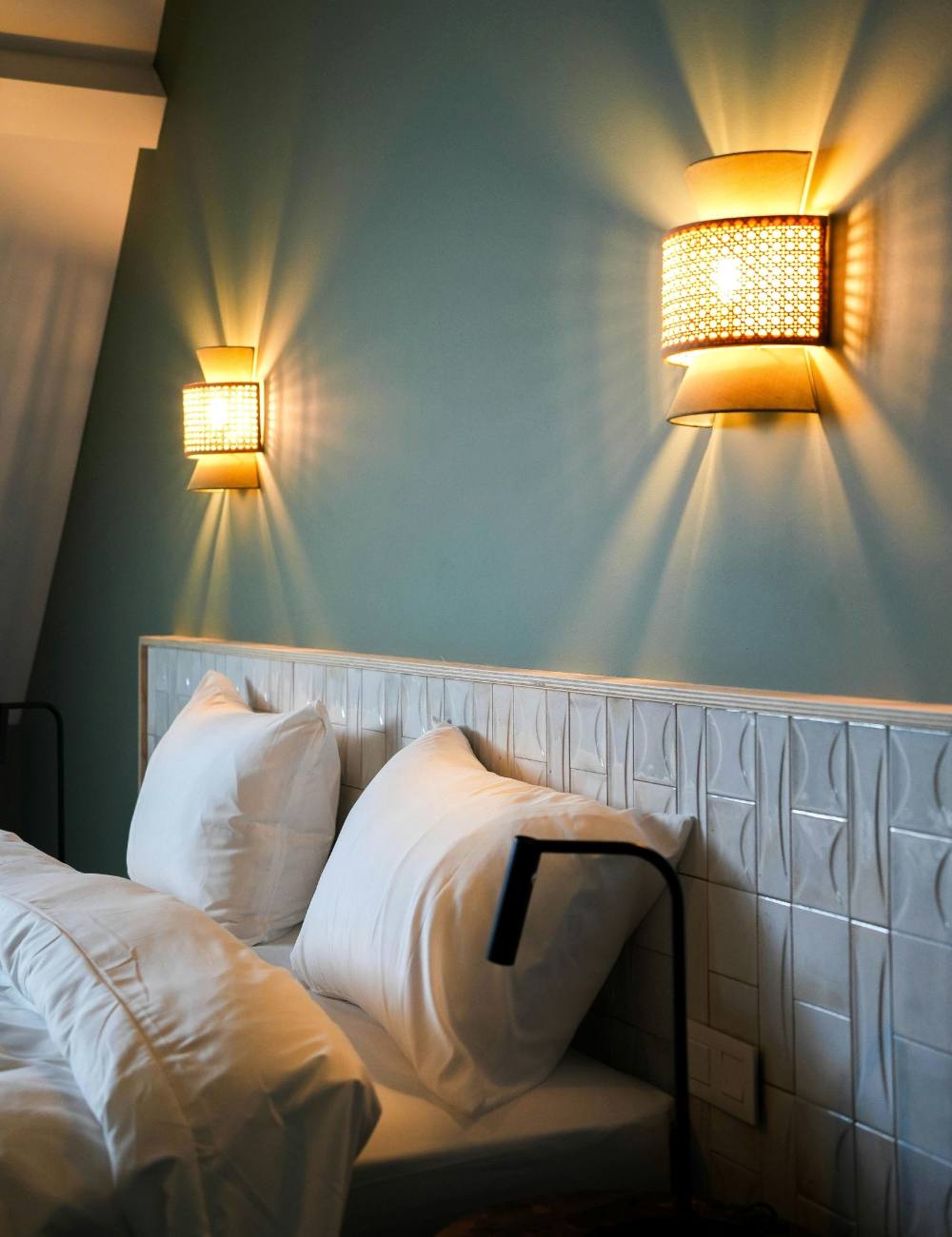 Lit avec appliques murales et mur vert bleuté