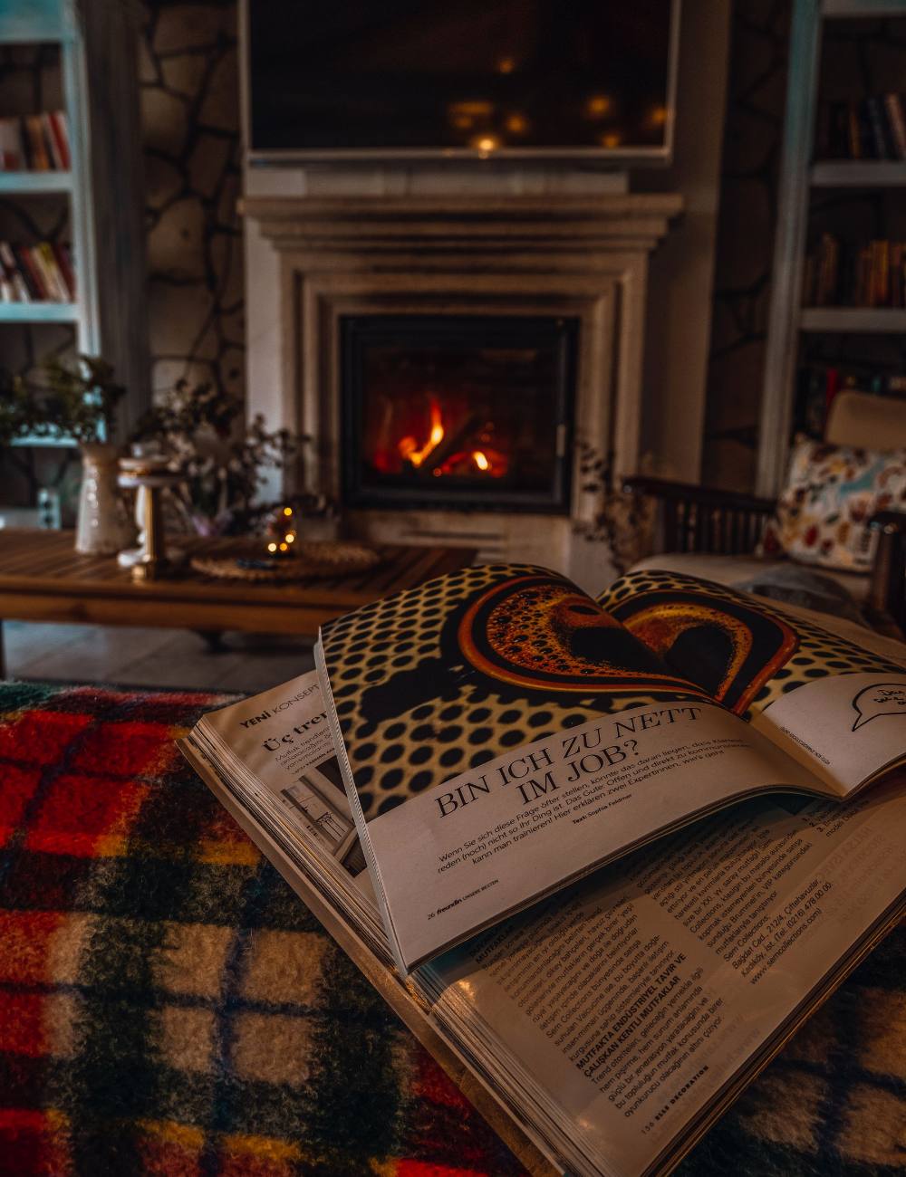Salon avec cheminée allumée et magazines