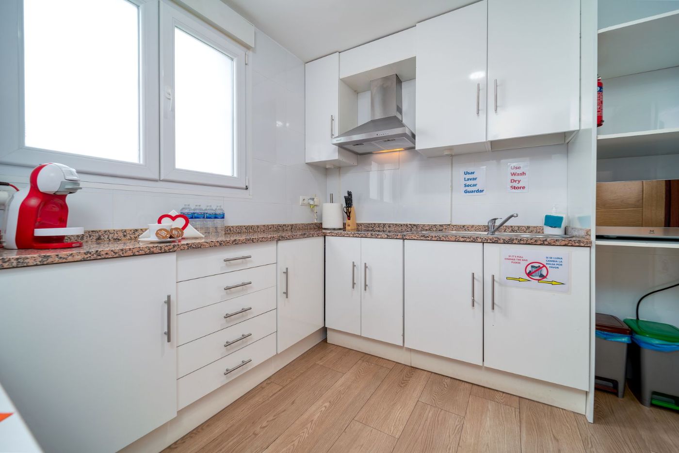 Cocina blanca con encimera de granito y ventanas grandes