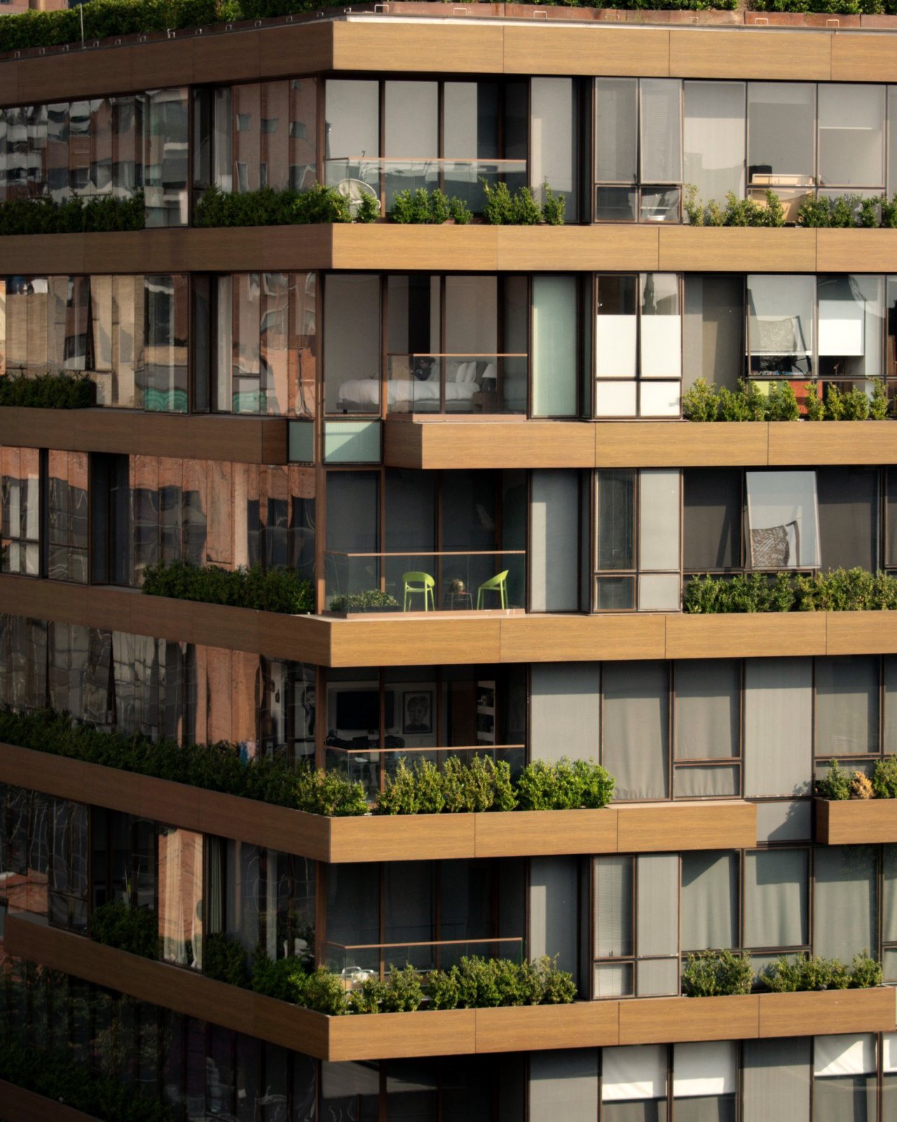 Fachada de un edificio de apartamentos con balcones de madera y plantas