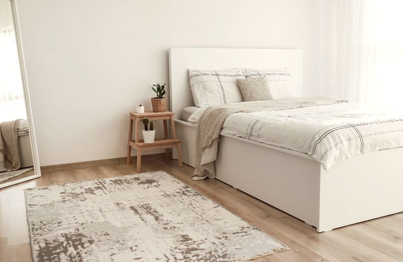 Dormitorio blanco con cama doble y alfombra clara