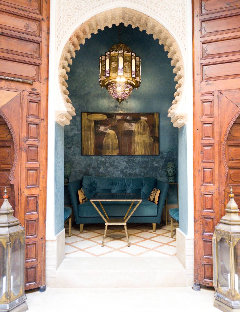 Salotto con pareti blu e porte di legno intagliate