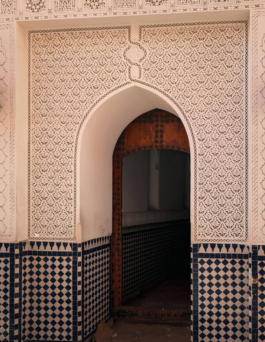 Arco di stucco intagliato con porta di legno