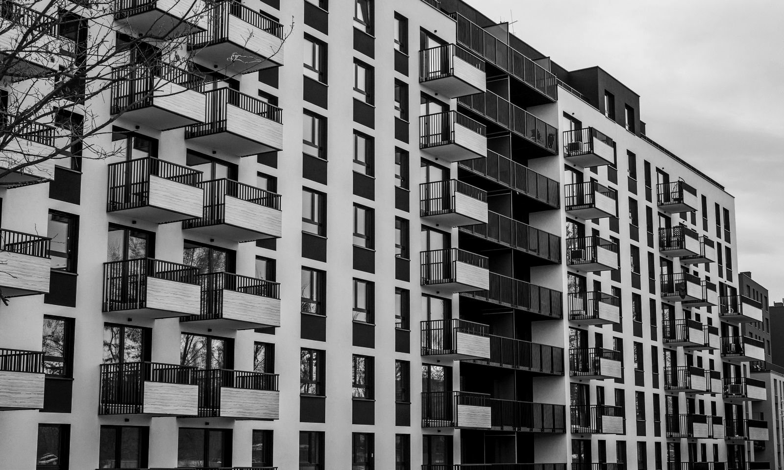 Fachada de un edificio de apartamentos con balcones, en blanco y negro