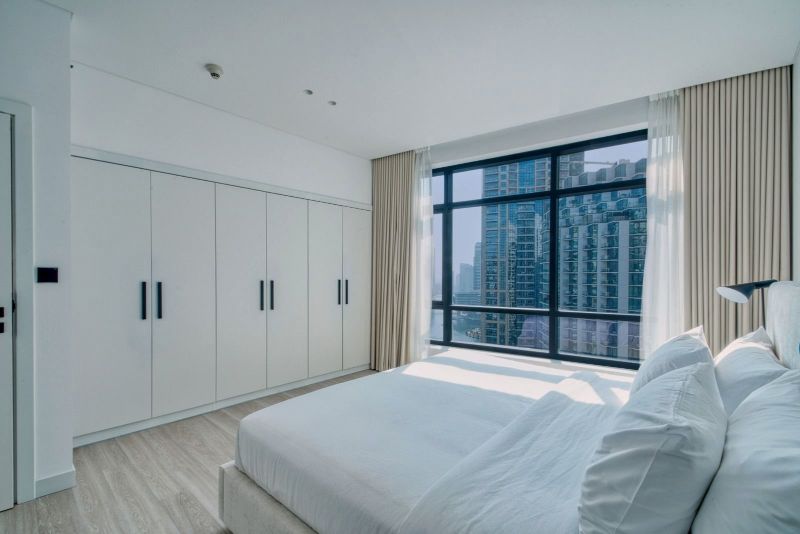 Cama doble con ventanal sobre la ciudad