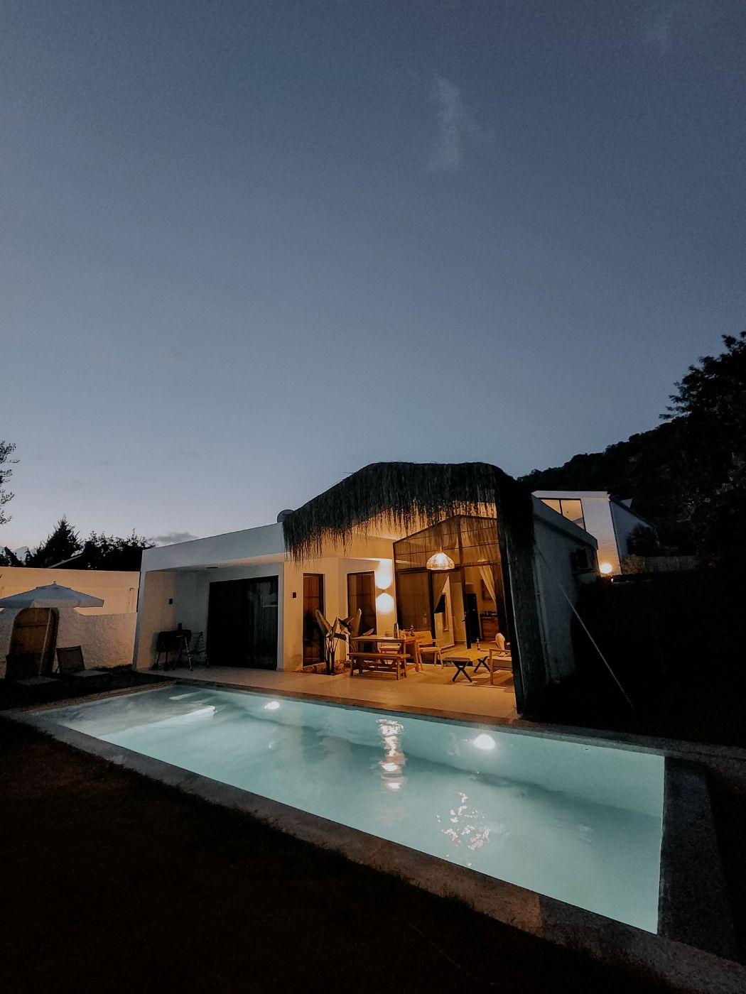 Villa con piscina iluminada al anochecer