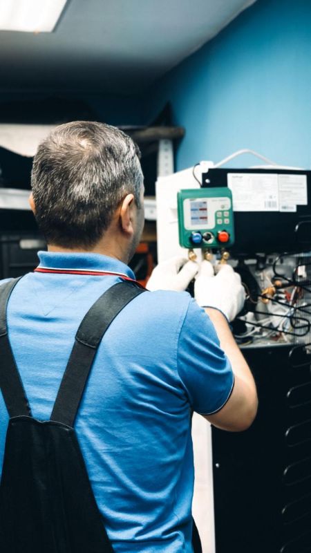 Técnico de espaldas revisando una instalación con manómetros