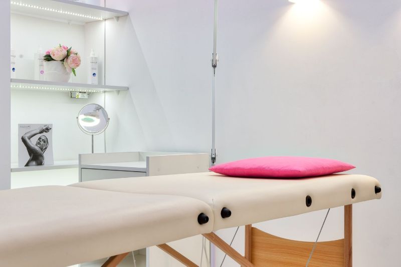 Lettino trattamento con cuscino rosa e specchio ingranditore