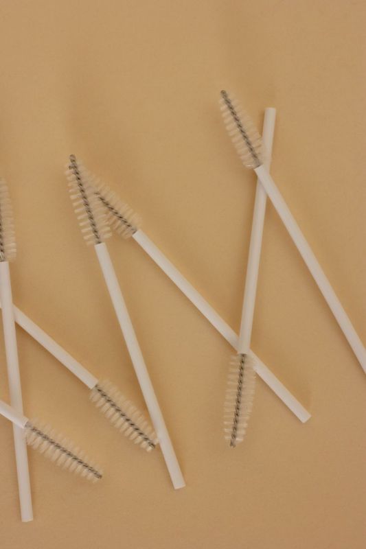 Spazzolini monouso a spirale su fondo sabbia