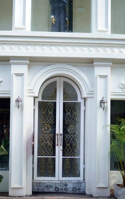 Entrada blanca con puerta de arco y cristales