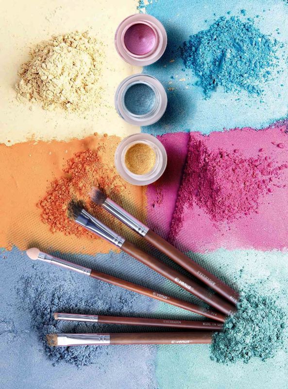 Polvos de colores y pinceles sobre una superficie pintada
