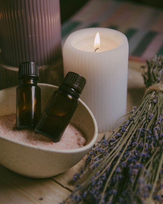 Fläschchen mit ätherischen Ölen, rosa Salz und Lavendel mit Kerze