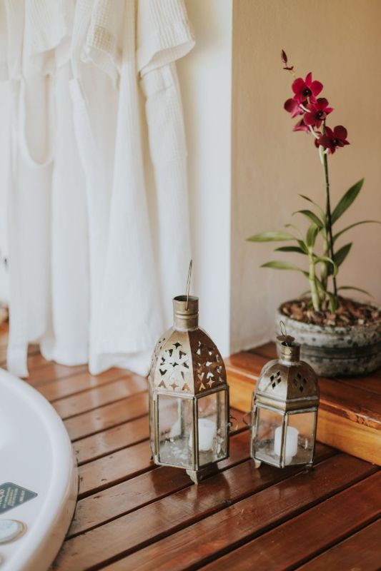 Farolillos y una orquídea junto a cortinas blancas