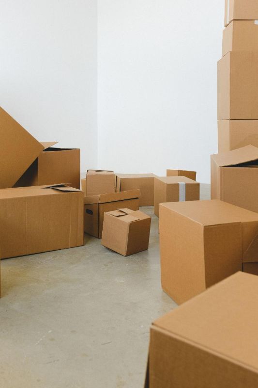 Cardboard boxes piled up in an empty, bright house