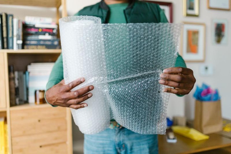 Person holding a roll of bubble wrap