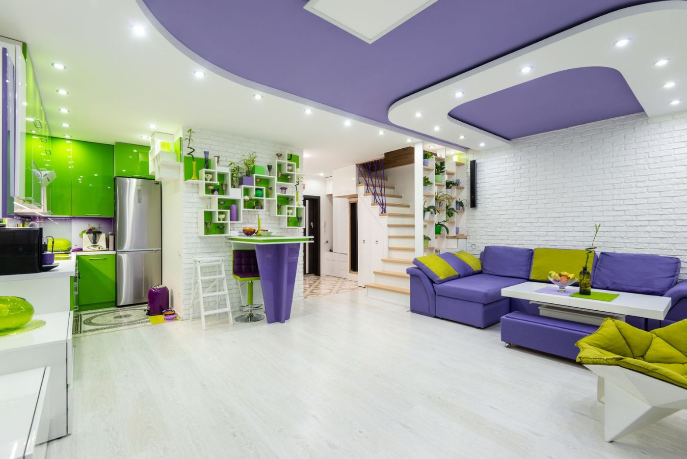 Séjour ouvert avec plafond violet et canapés colorés