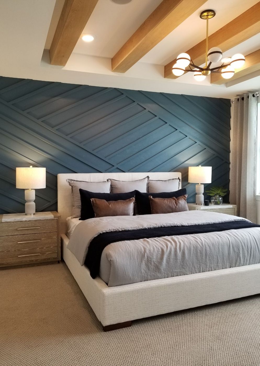 Chambre avec mur d’accent bleu foncé et lattes en diagonale