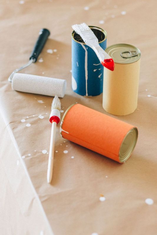 Pinceaux, rouleaux et pots de peinture sur papier de protection