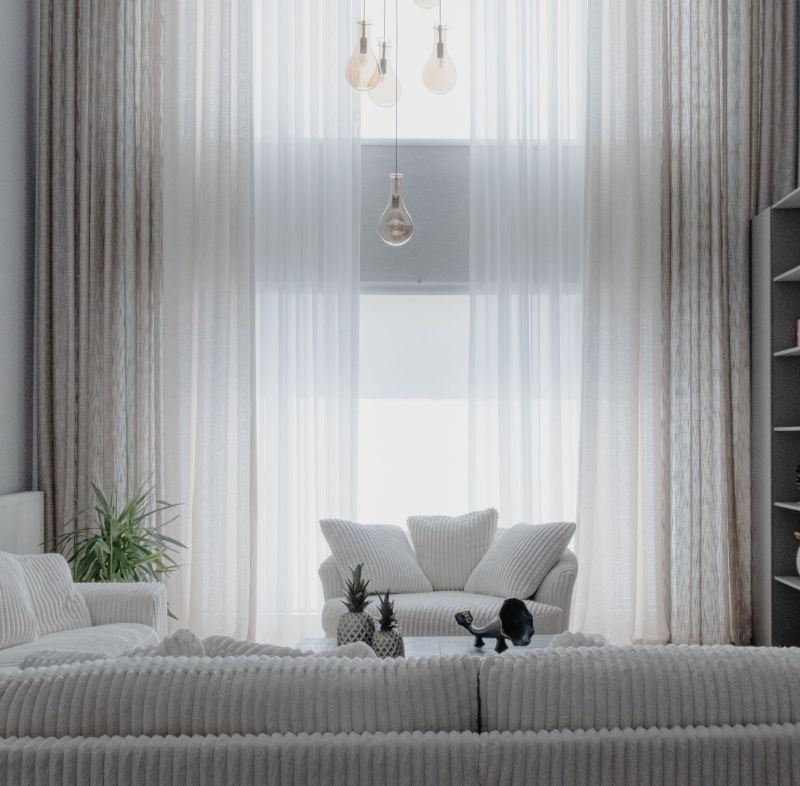 Salón luminoso con sofás blancos y cortinas