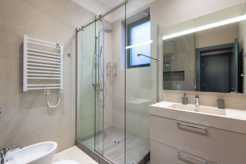 Ducha con mampara de cristal junto al lavabo