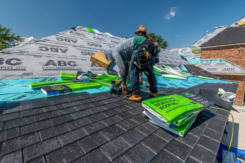Two workers laying the base of a new roof