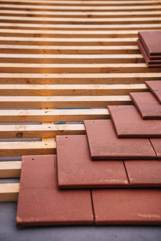 Listelli di legno e tegole accatastate durante il lavoro