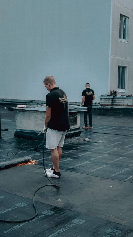 Zwei Personen bei der Arbeit auf einem Flachdach