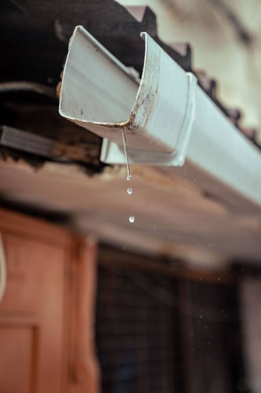 Drops falling from a white gutter