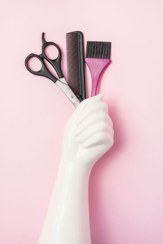 Main de mannequin avec ciseaux et peigne