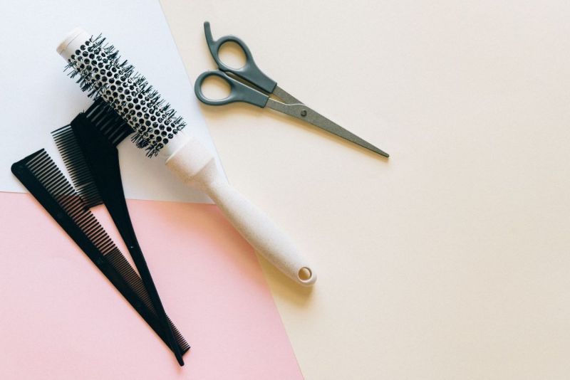 Brosses, ciseaux et pinces sur fond pastel