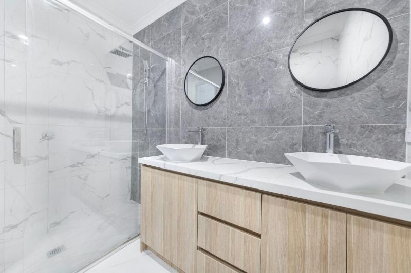 Baño con doble lavabo y ducha de cristal