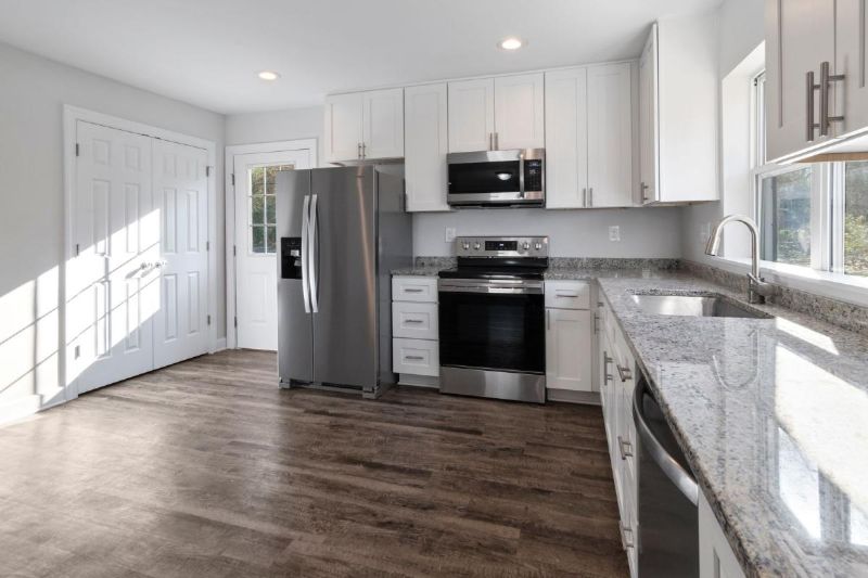 Kitchen with white units and a wooden floor