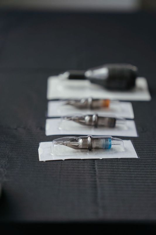 Packaged tattoo cartridges in a row on a black cloth