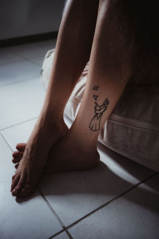 Ankle with a small fine-line tattoo