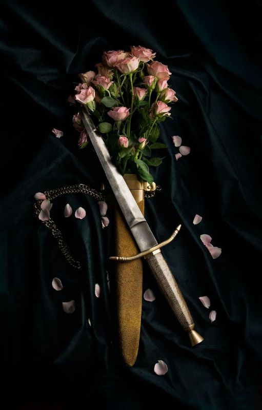 A dagger and pink roses on black velvet, classic flash motifs